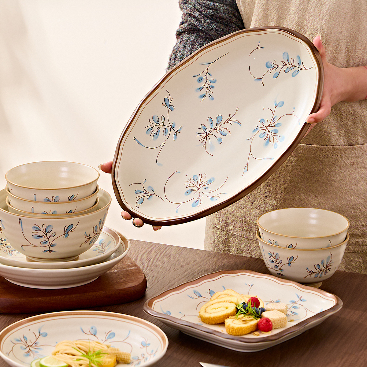 Simple Retro fish plate held up above bowls and plates on a table. Food and props not included.