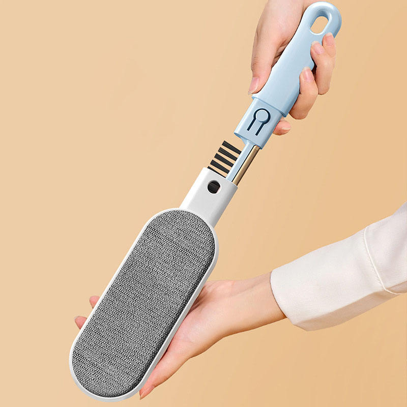 Hands separating the blue pet hair remover brush to show the built-in comb