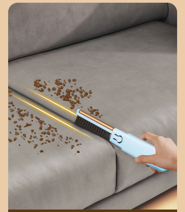 Blue pet hair remover brush comb clearing debris from a gray sofa seam