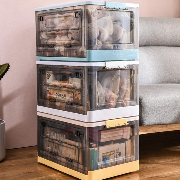 Three stacked storage boxes holding toys and books beside a sofa