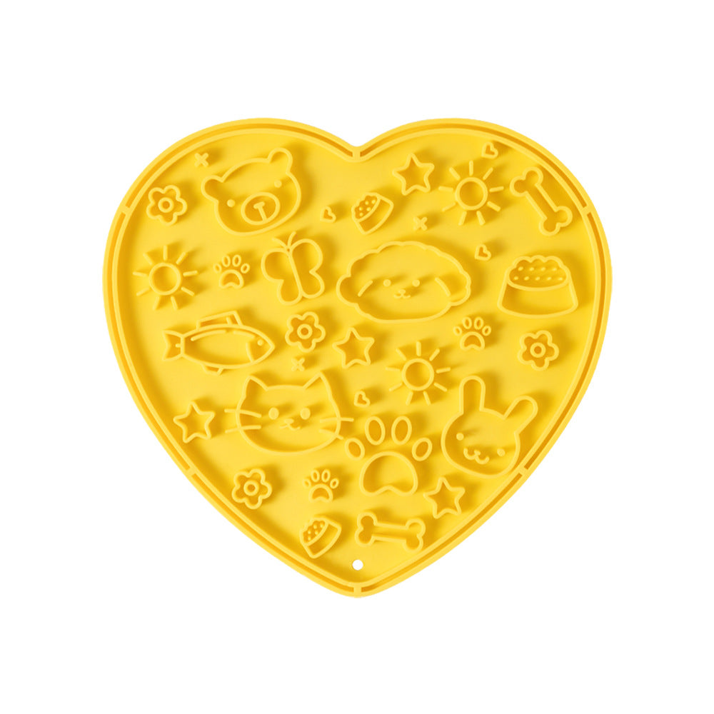 Yellow heart-shaped silicone lick mat with a molded pattern, on a white background
