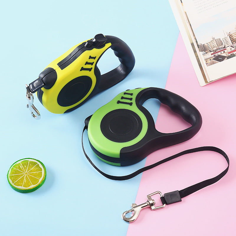 Yellow and green retractable leashes on a blue and pink backdrop beside a lime slice and an open book