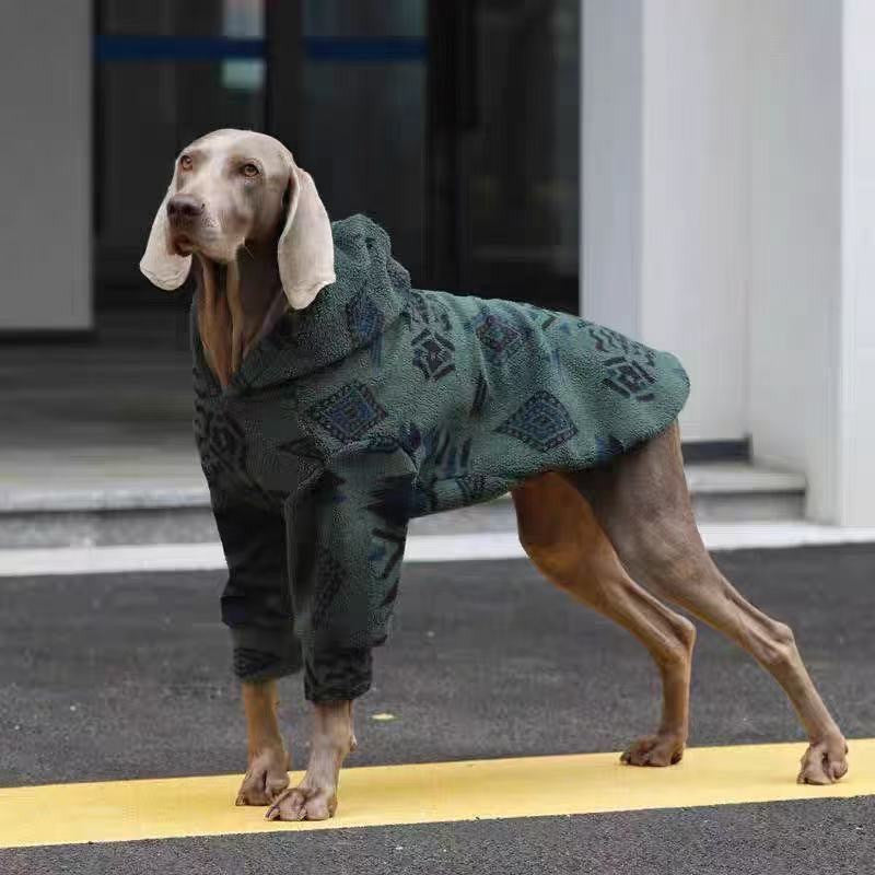 Grey Weimaraner standing outdoors in the dark green patterned fleece, seen from the side