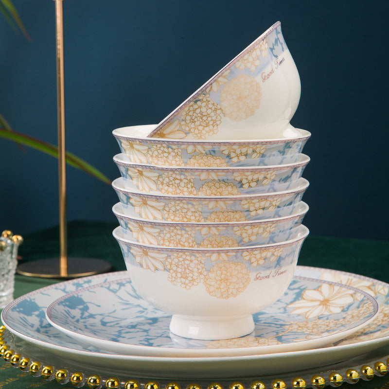 Five footed rice bowls stacked on a dinner plate, showing the pattern repeating across pieces