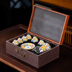 The cups and saucer nested in a lined presentation case with the hinged wooden lid open.
