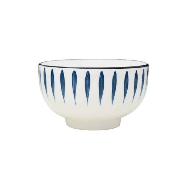 A single footed rice bowl on a white background, white glaze with hand-painted navy leaf strokes and a thin dark rim.