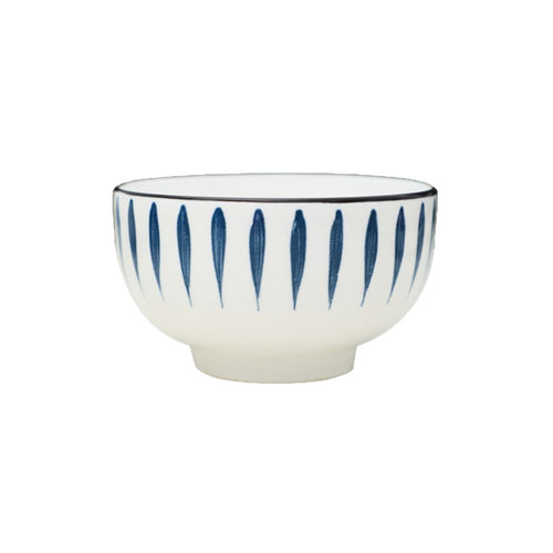 A single footed rice bowl on a white background, white glaze with hand-painted navy leaf strokes and a thin dark rim.
