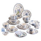 The blue and white set arranged on a white background: an oval platter, plates and bowls printed with small blue flowers, a lidded soup bowl and shallow dishes.