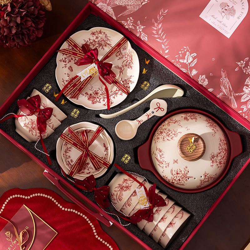 Red Botanical Table Set in a Gift Box. A cream body with a red botanical print that runs across the plates, inside the bowls and over the lid of the covered pot.