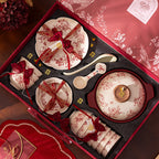 Red Botanical Table Set in a Gift Box. A cream body with a red botanical print that runs across the plates, inside the bowls and over the lid of the covered pot.