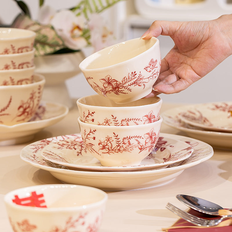 Red Botanical Table Set in a Gift Box. A cream body with a red botanical print that runs across the plates, inside the bowls and over the lid of the covered pot.