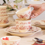 Red Botanical Table Set in a Gift Box. A cream body with a red botanical print that runs across the plates, inside the bowls and over the lid of the covered pot.