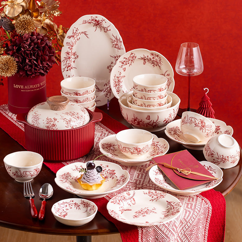 Red Botanical Table Set in a Gift Box. A cream body with a red botanical print that runs across the plates, inside the bowls and over the lid of the covered pot.