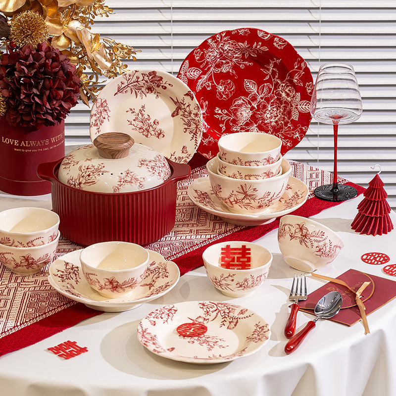 Red Botanical Table Set in a Gift Box. A cream body with a red botanical print that runs across the plates, inside the bowls and over the lid of the covered pot.