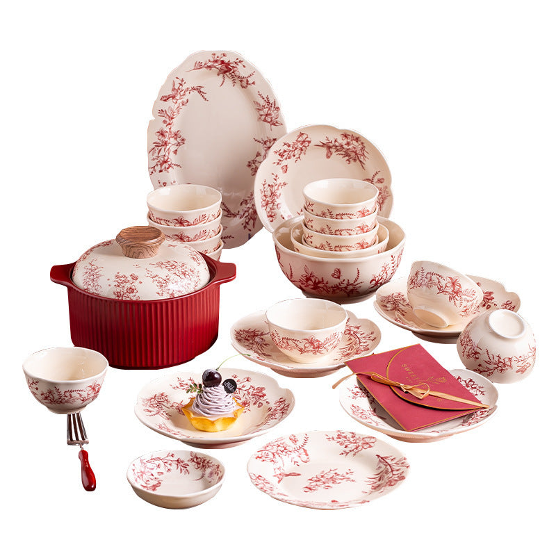 Red Botanical Table Set in a Gift Box. A cream body with a red botanical print that runs across the plates, inside the bowls and over the lid of the covered pot.