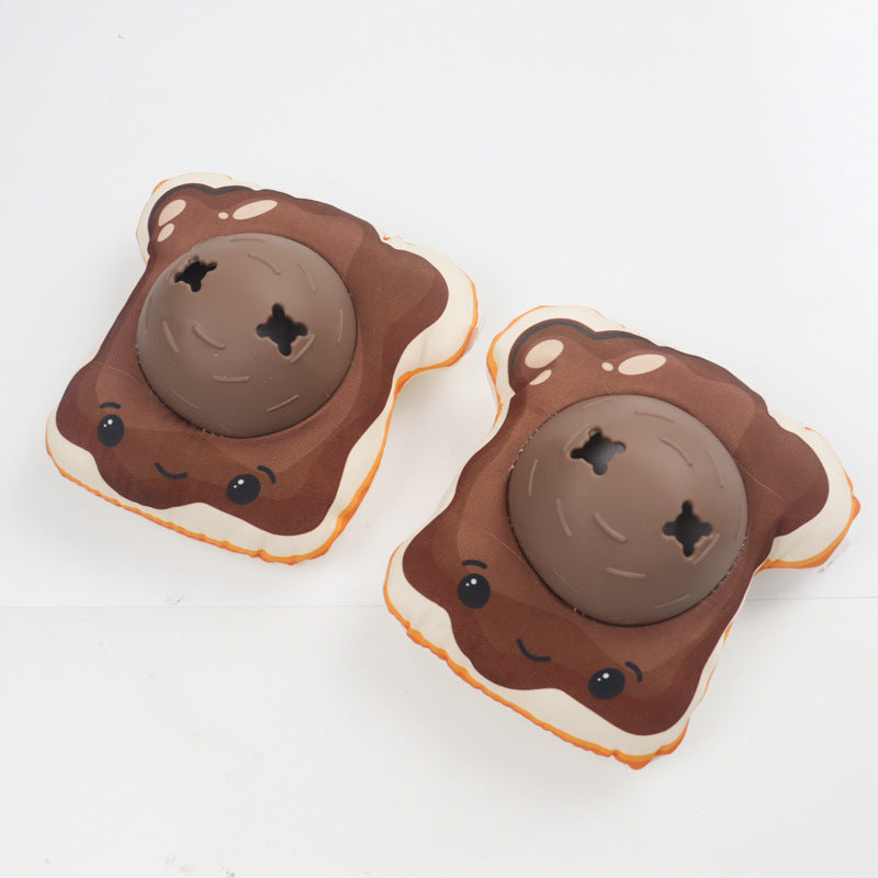 Two bread-style plush dog toys in brown with cream crusts and brown balls