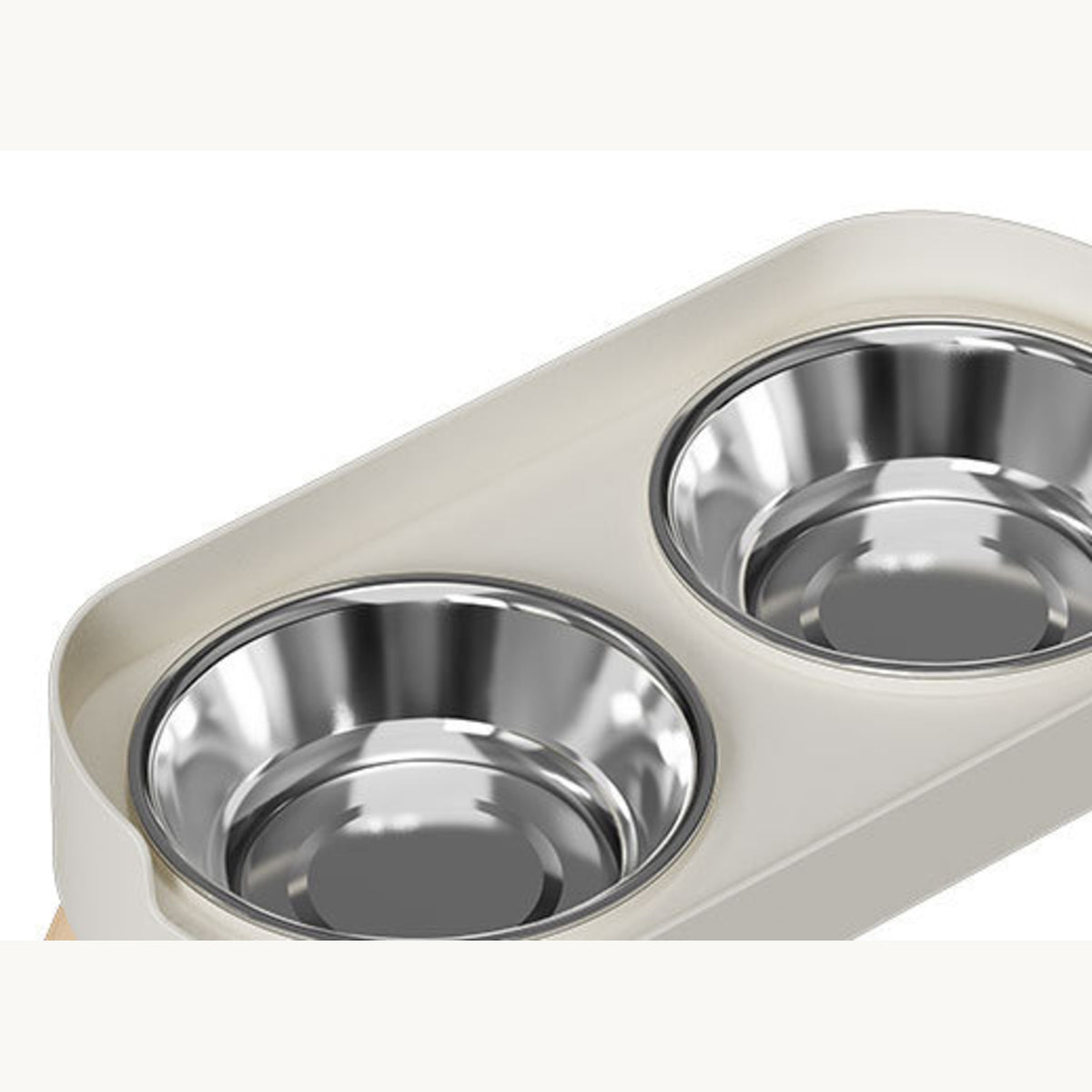 Two stainless steel bowls seated in the cut-outs of the ivory white frame