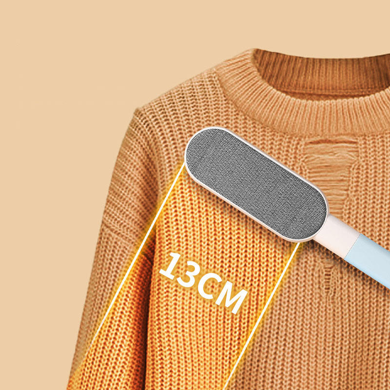 Double-sided pet hair remover brush on an orange sweater with the 13 cm brush head marked