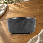 Rock Texture black 4.5 in rice bowl on a wooden table in soft daylight.