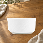Rock Texture white 4.5 in rice bowl on a wooden table in soft daylight.