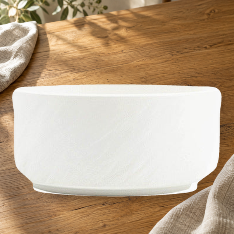 Rock Texture white 7.5 in soup bowl on a wooden table in soft daylight.