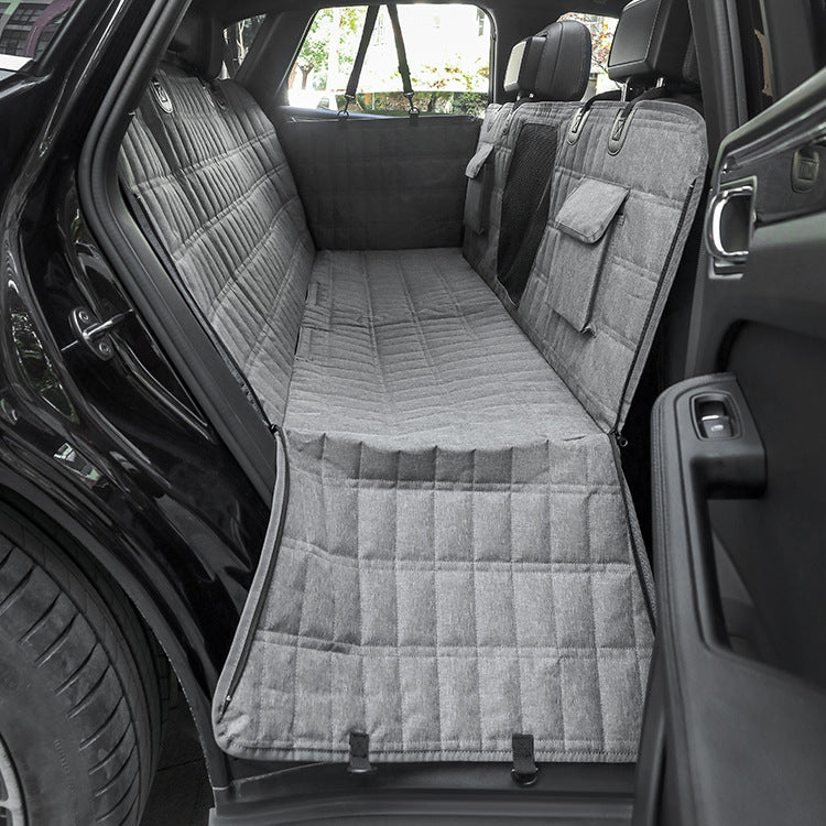 Light gray quilted dog back seat cover fitted across a car's rear seat with side flaps