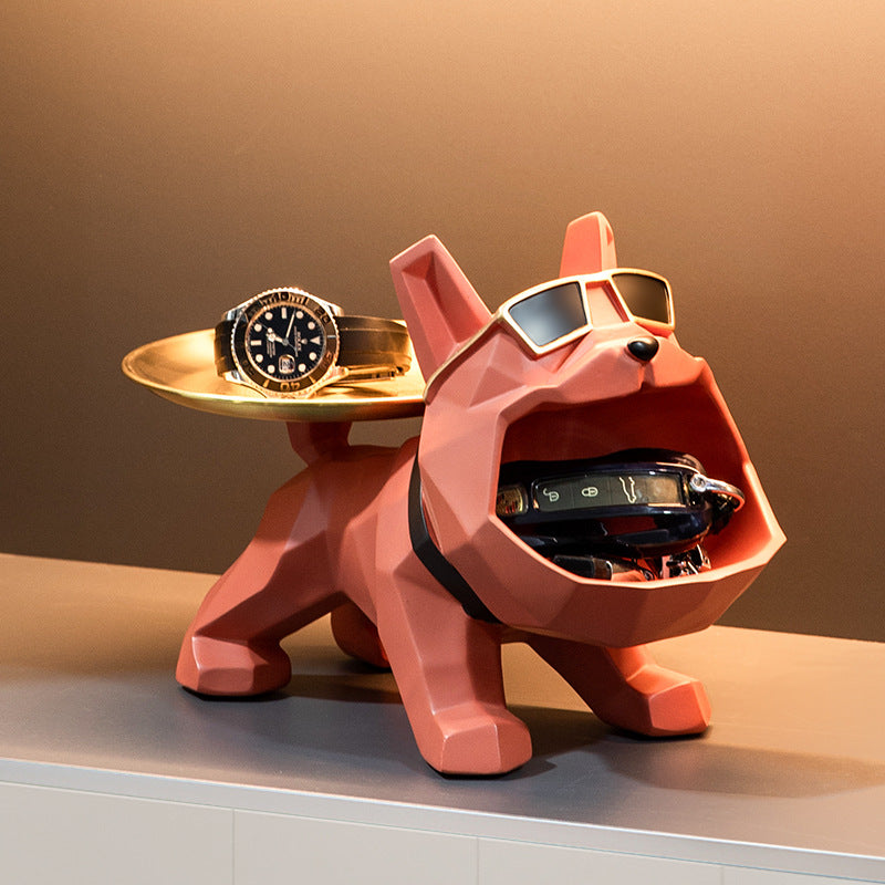 Coral bulldog figurine catch-all with a watch on the gold tray