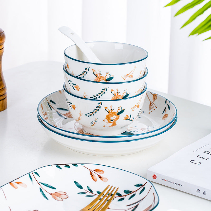 Stacked deer-pattern bowls on matching plates, with a spoon.