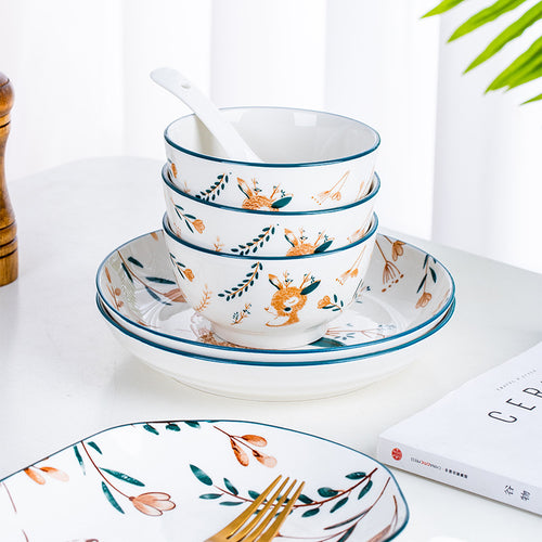 Stacked deer-pattern bowls on matching plates, with a spoon.