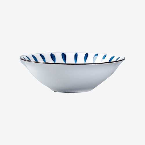 A flared white bowl with blue brushed petals inside the rim, seen from the side.