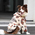 Border collie sitting in a doorway in the cream geometric-patterned fleece coat