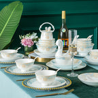 The set styled on a dining table with glassware, a swan serving piece and flowers