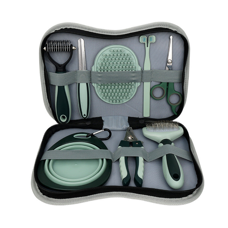 Sage green dog grooming kit in its zip carry case: dematting rake, nail file, silicone bath brush, toothbrush, round-tip scissors, collapsible bowl, nail clipper and slicker brush