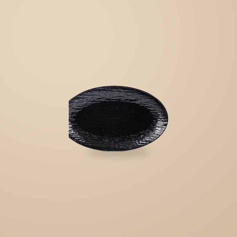 Rock Texture black 12 in oval platter, on a warm beige background.