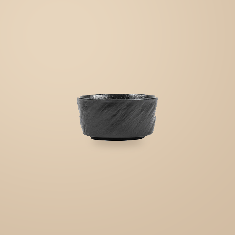 Rock Texture black 4.5 in rice bowl, on a warm beige background.