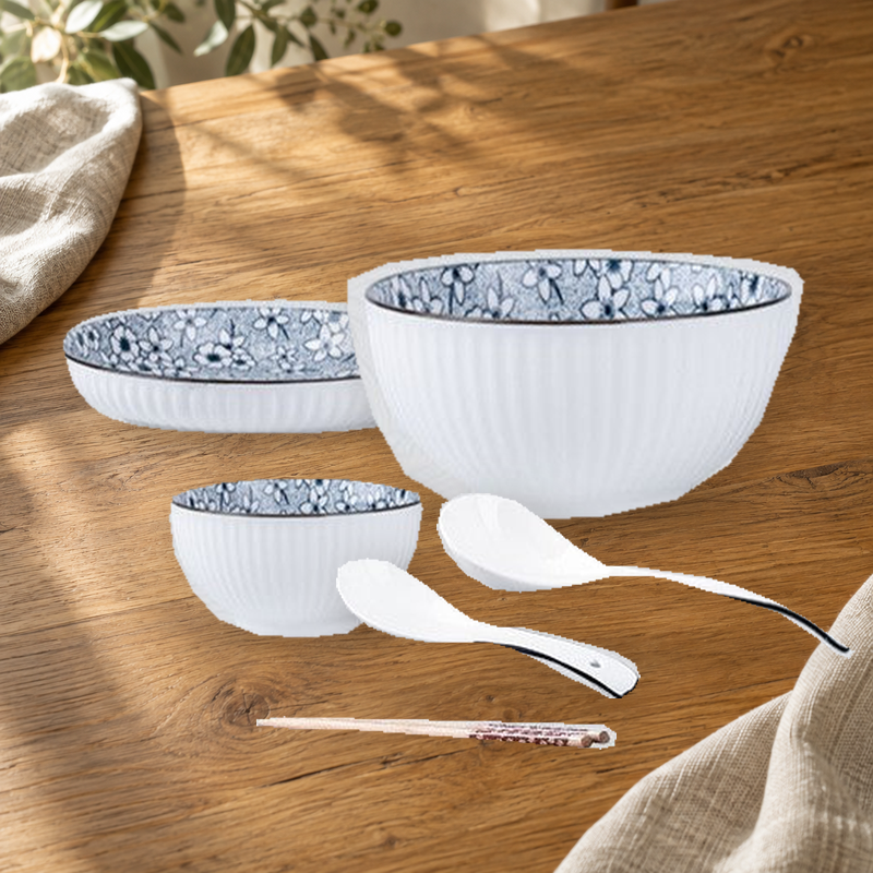 Yamada Sakura pattern pieces on a wooden table: rice bowl, plate, soup bowl, spoons and chopsticks.