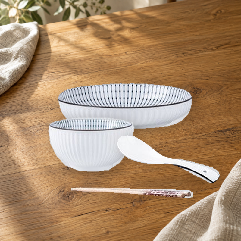 Yamada Spring pattern pieces on a wooden table: rice bowl, plate, spoon and chopsticks.