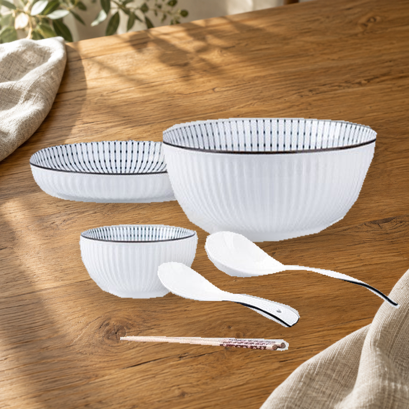Yamada Spring pattern pieces on a wooden table: rice bowl, plate, soup bowl, spoons and chopsticks.