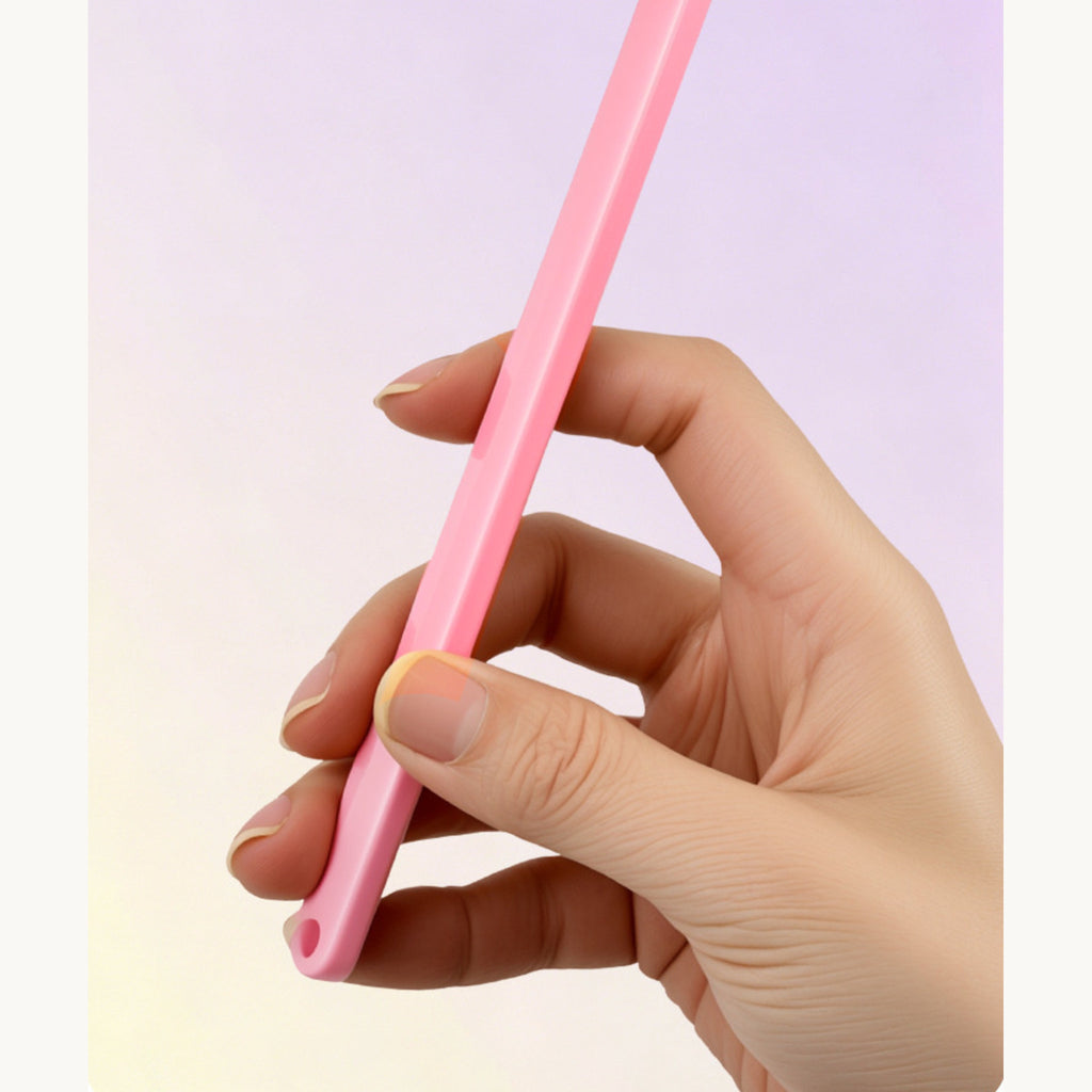 The pink cat toothbrush held in one hand, showing the length of the handle