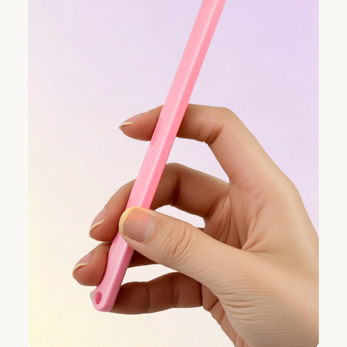 The pink cat toothbrush held in one hand, showing the length of the handle