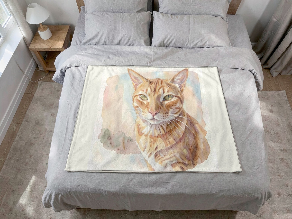 Example cat artwork: a watercolor portrait of an orange tabby cat printed on a fleece blanket on a bed