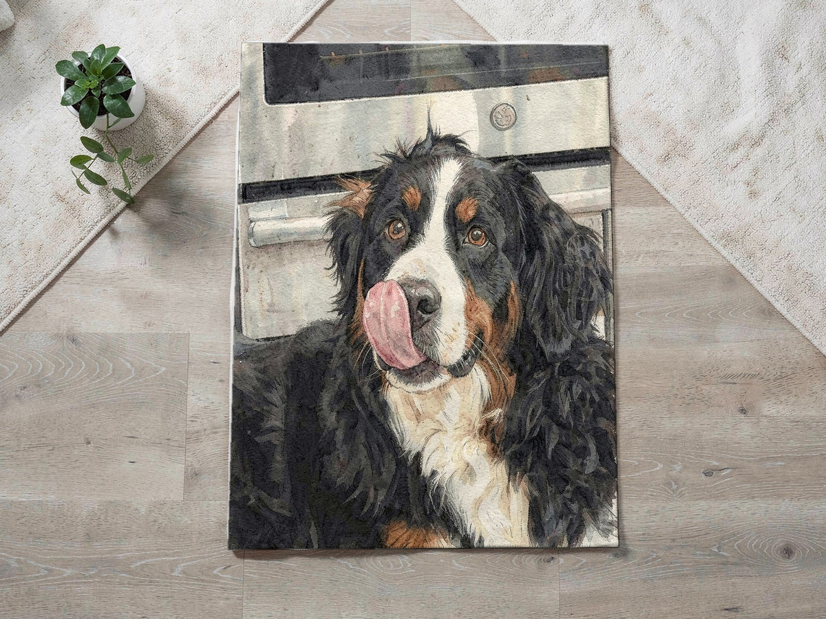 Example custom blanket on a wood floor: a watercolor portrait of a Bernese Mountain Dog licking his nose, printed on a fleece throw