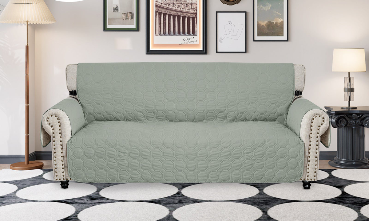 Mint green quilted sofa cover on a three-seat sofa in a living room