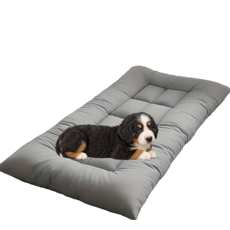 Bernese mountain dog puppy lying on the grey oversized quilted dog mat