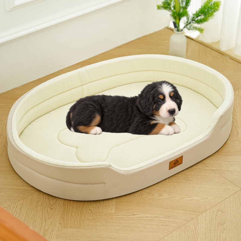 Bernese mountain dog puppy lying on the small cream oval dog bed with a raised rim