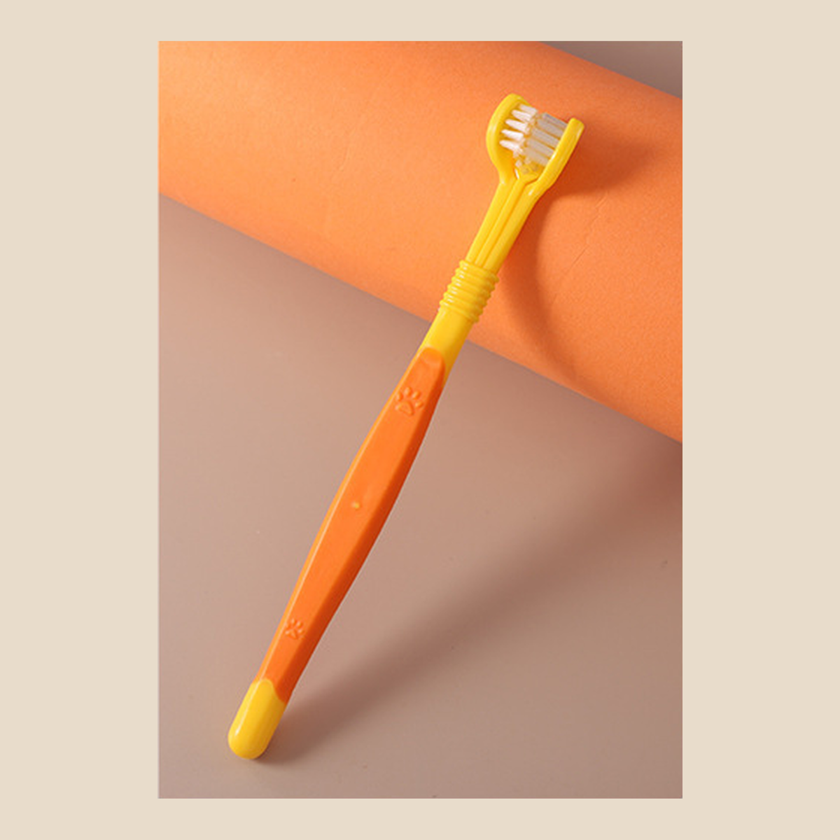 Yellow three-sided dog toothbrush with an orange grip panel