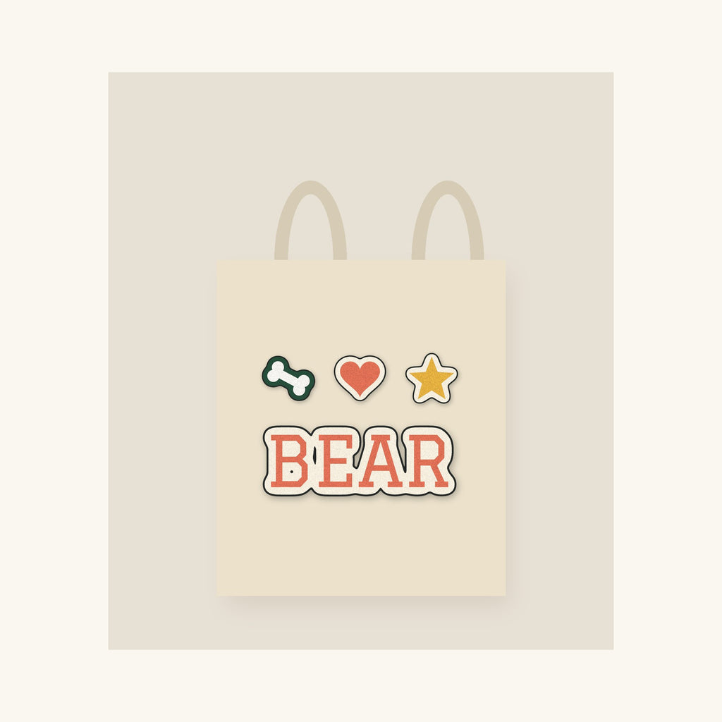 Natural canvas tote with a dog's name in printed varsity-style lettering and three small icons
