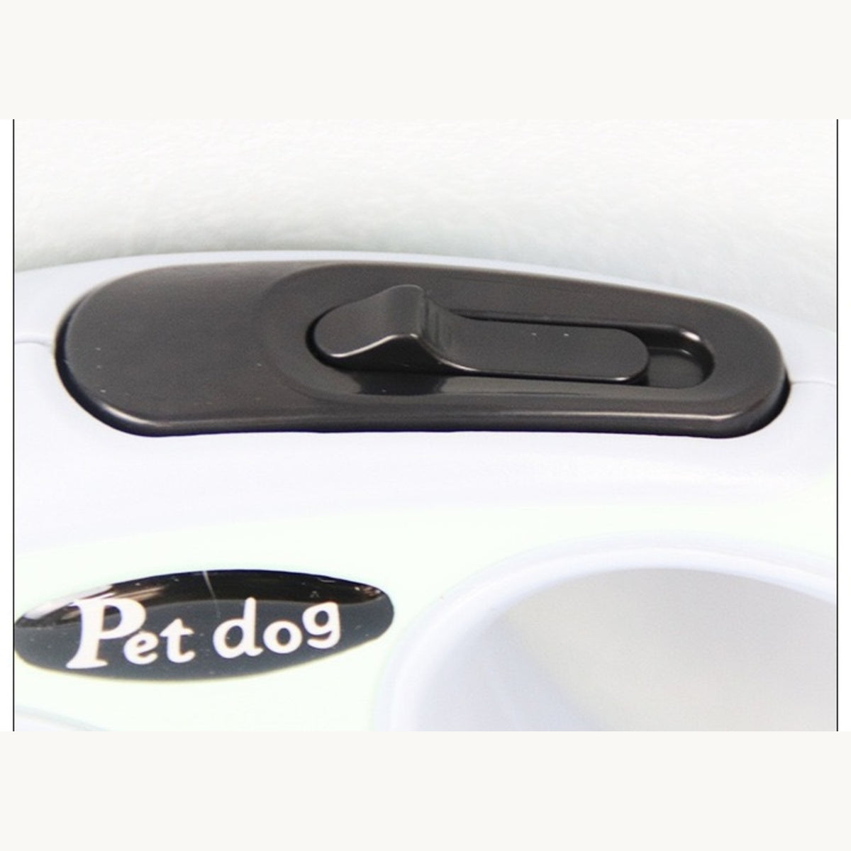Close-up of the retractable leash case's thumb brake and lock button