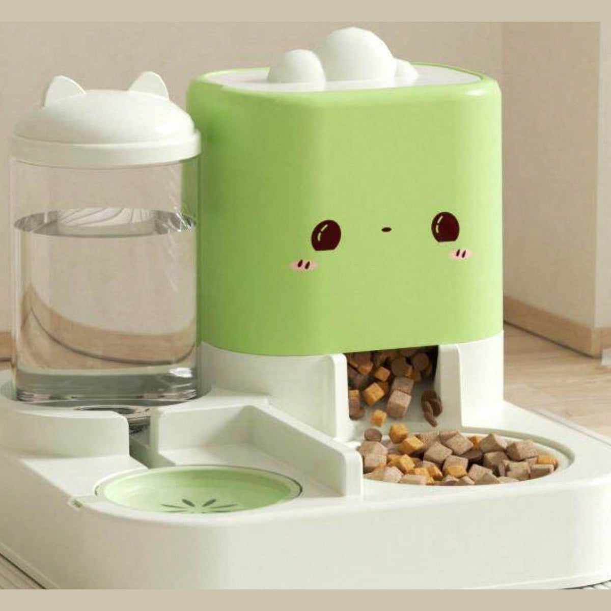 Green 2-in-1 gravity pet feeder: clear water bottle with a cat-ear lid on the left, mint-green dry-food hopper with a cat face on the right, both on one white base with a kibble bowl and a water dish