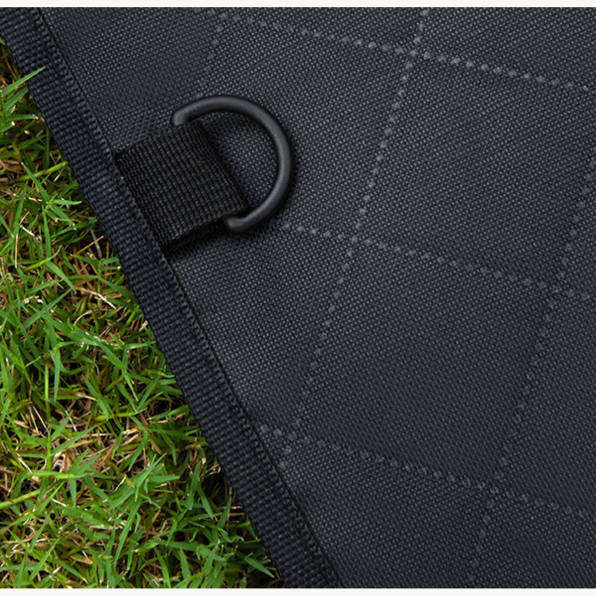 Close-up of a D-ring anchor sewn into the quilted car seat cover